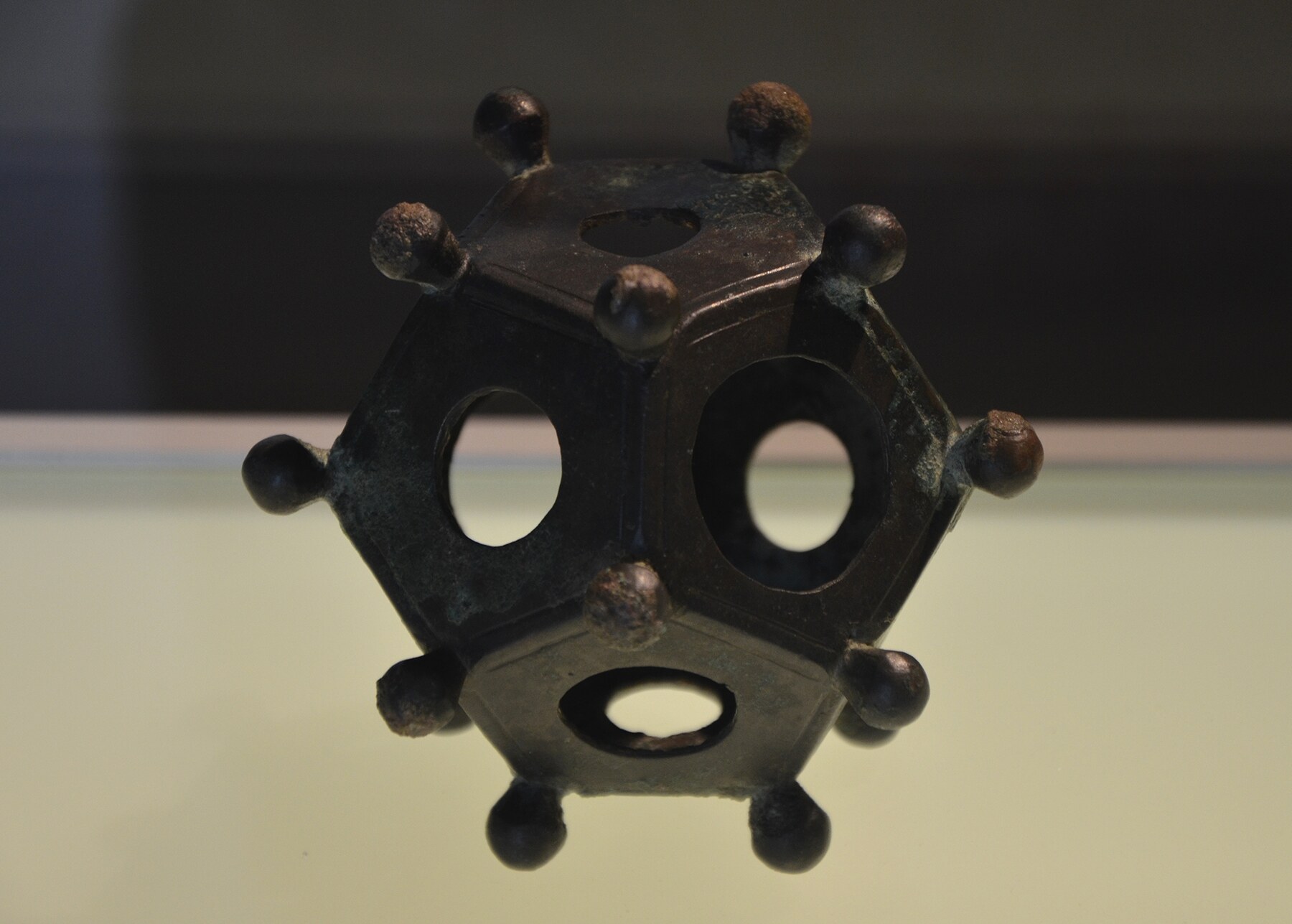 A hollow copper-alloy Roman dodecahedron with differently sized holes and rounded corner knobs